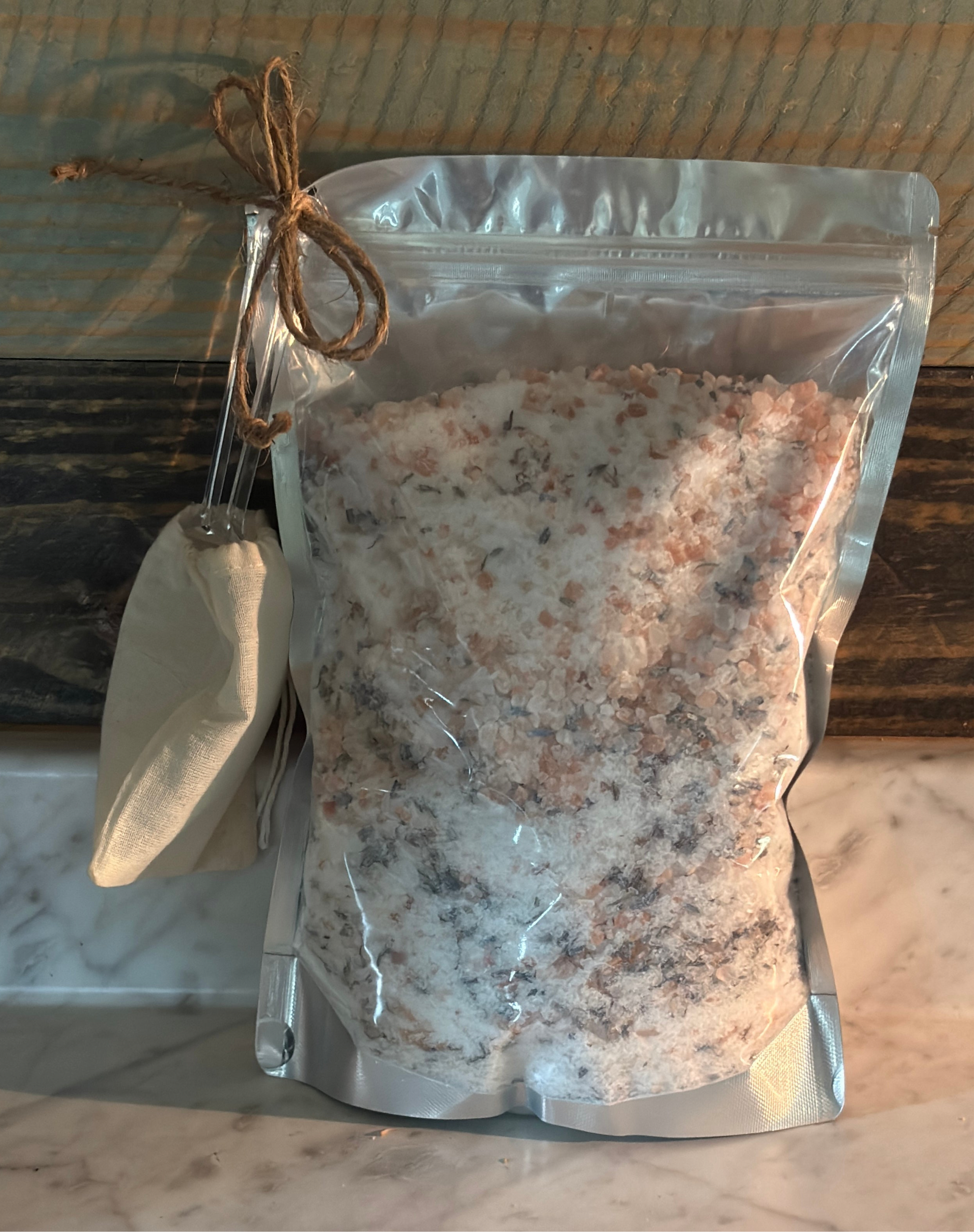 Bag of bath salts with a small scoop on a wooden surface