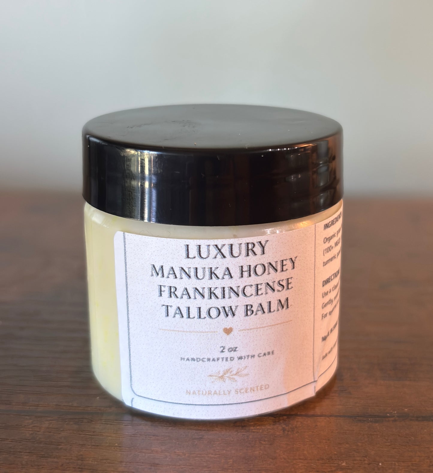 Jar of Luxury Manuka Honey Frankincense Tallow Balm on a wooden surface