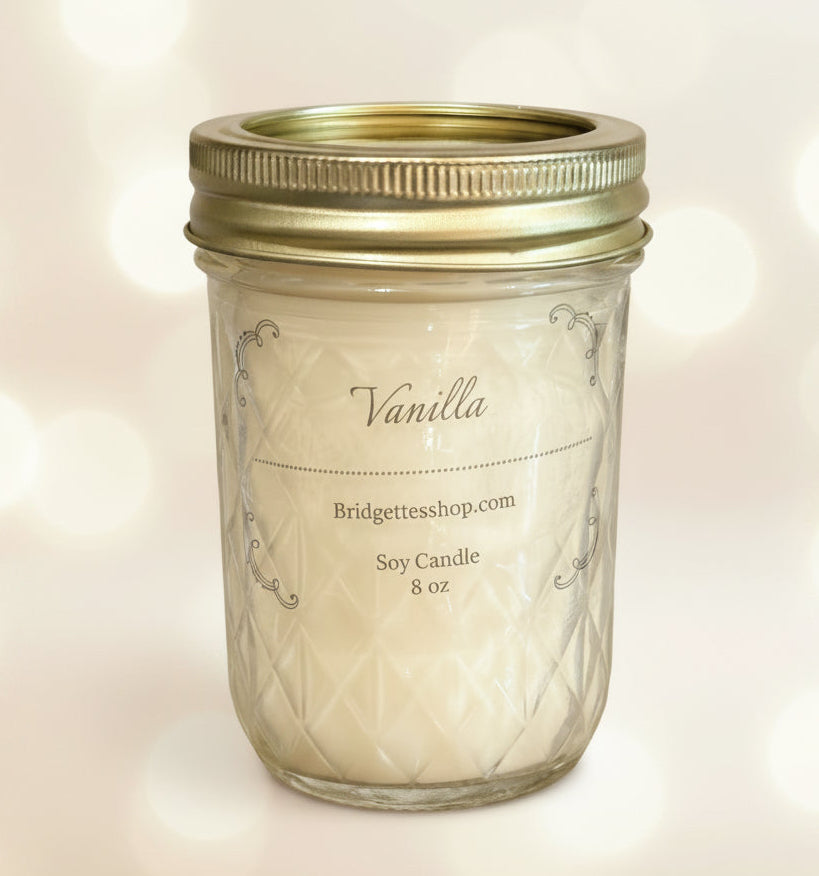 Vanilla candle in a mason jar with a gold lid on a light background