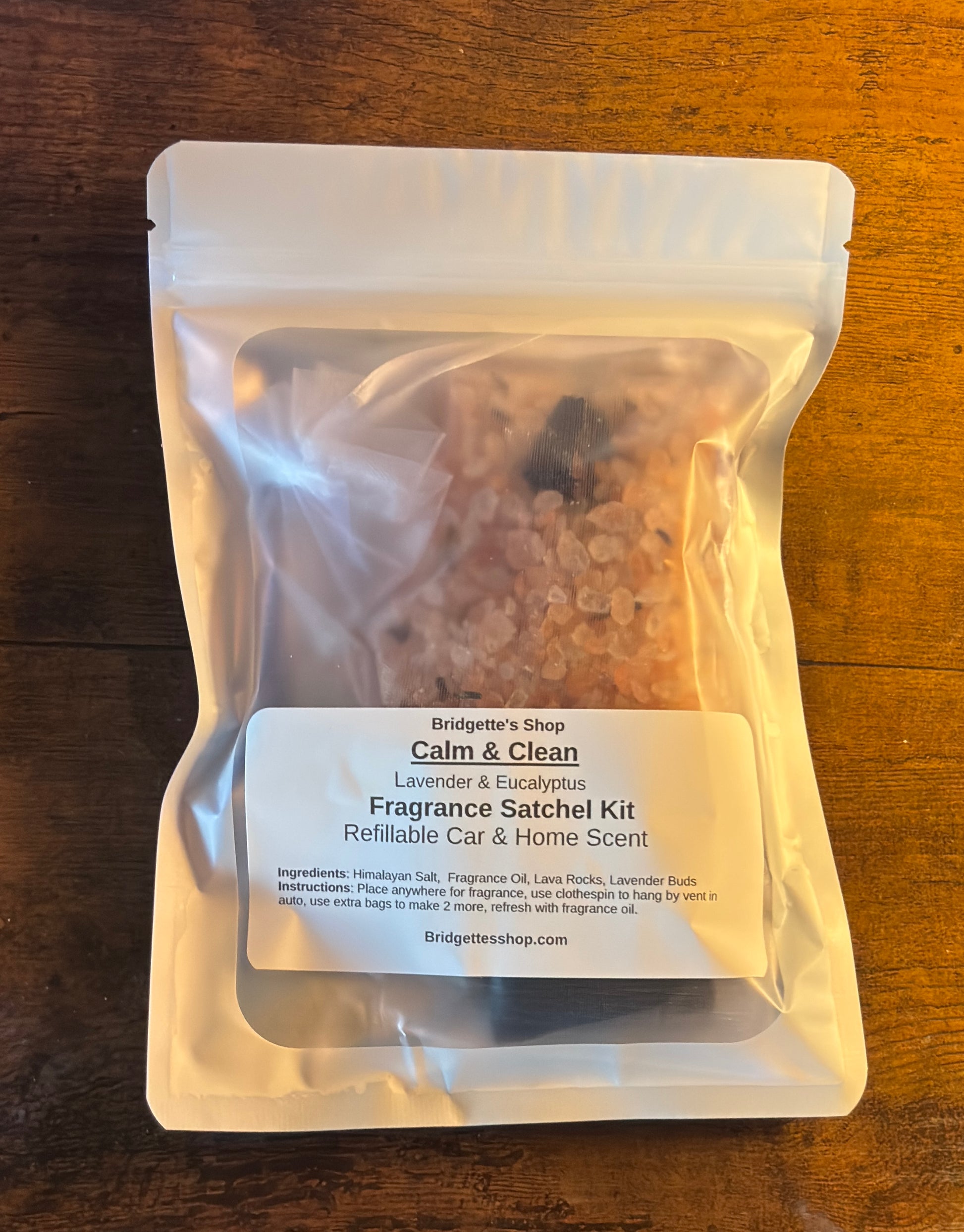 Fragrance satchel kit labeled 'Calm & Clean' on a wooden surface