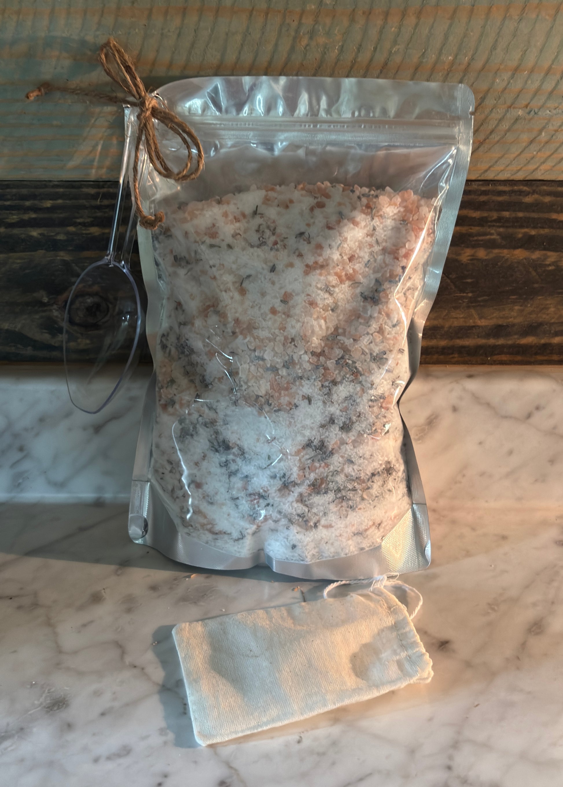 Packaged bath salt on a marble surface with a wooden background