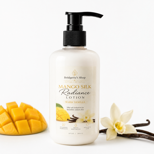 Bottle of Mango Silk Radiance Lotion with mango pieces, vanilla beans, and a vanilla flower on a white background