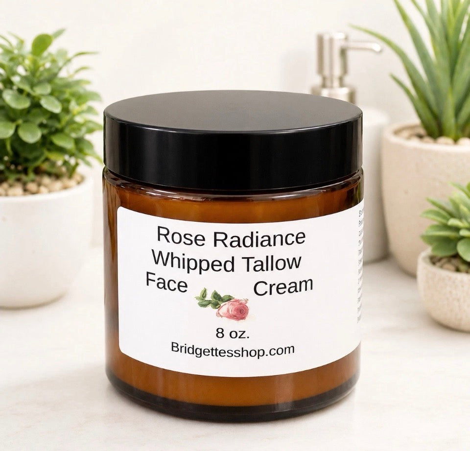 Jar of Rose Radiance Whipped Tallow Face Cream with a black lid on a white surface with plants in the background.